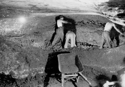 Men working in cave digging out dirt