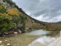 River with hillside where some fall color is appearing