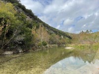 Hillside beside the river with a little color showing.