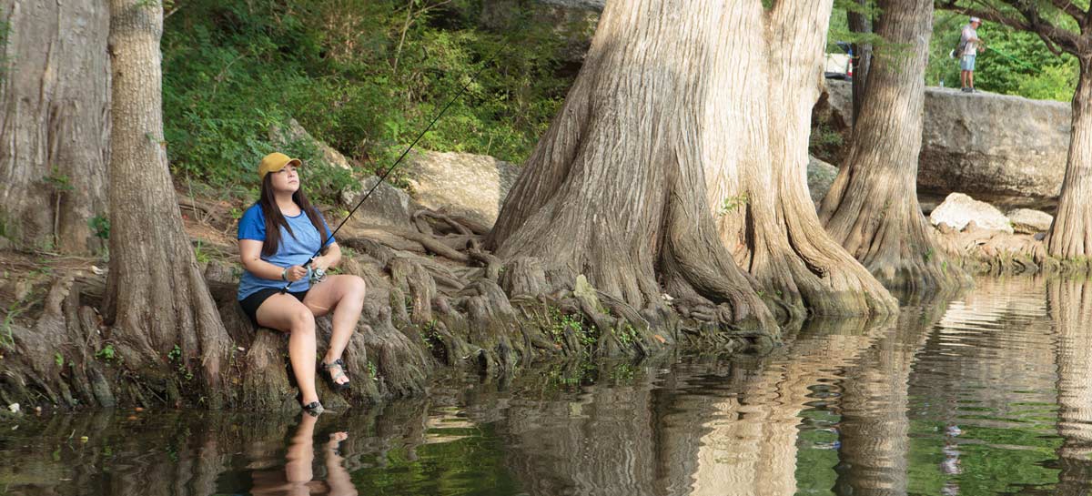 Woman fishing from the bank of the creek.