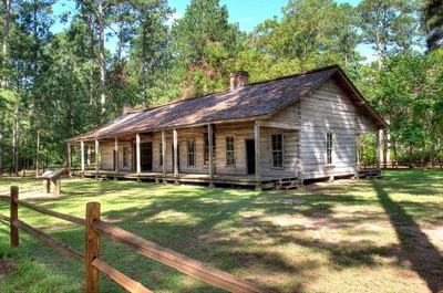 log cabin with split -rail fence in front.