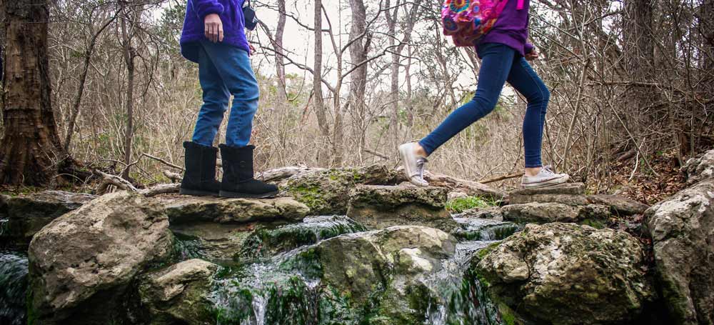 Kids hiking over a stream