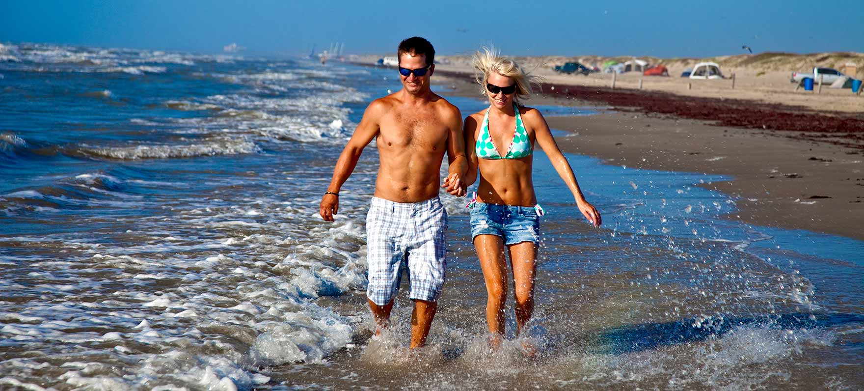 couple walking in water alone shore