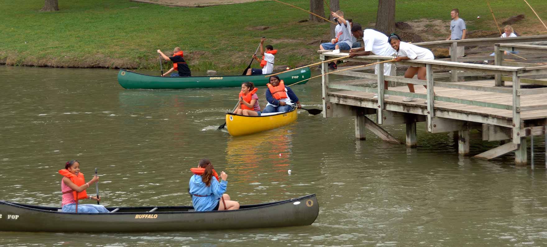 kids canoeing by pier