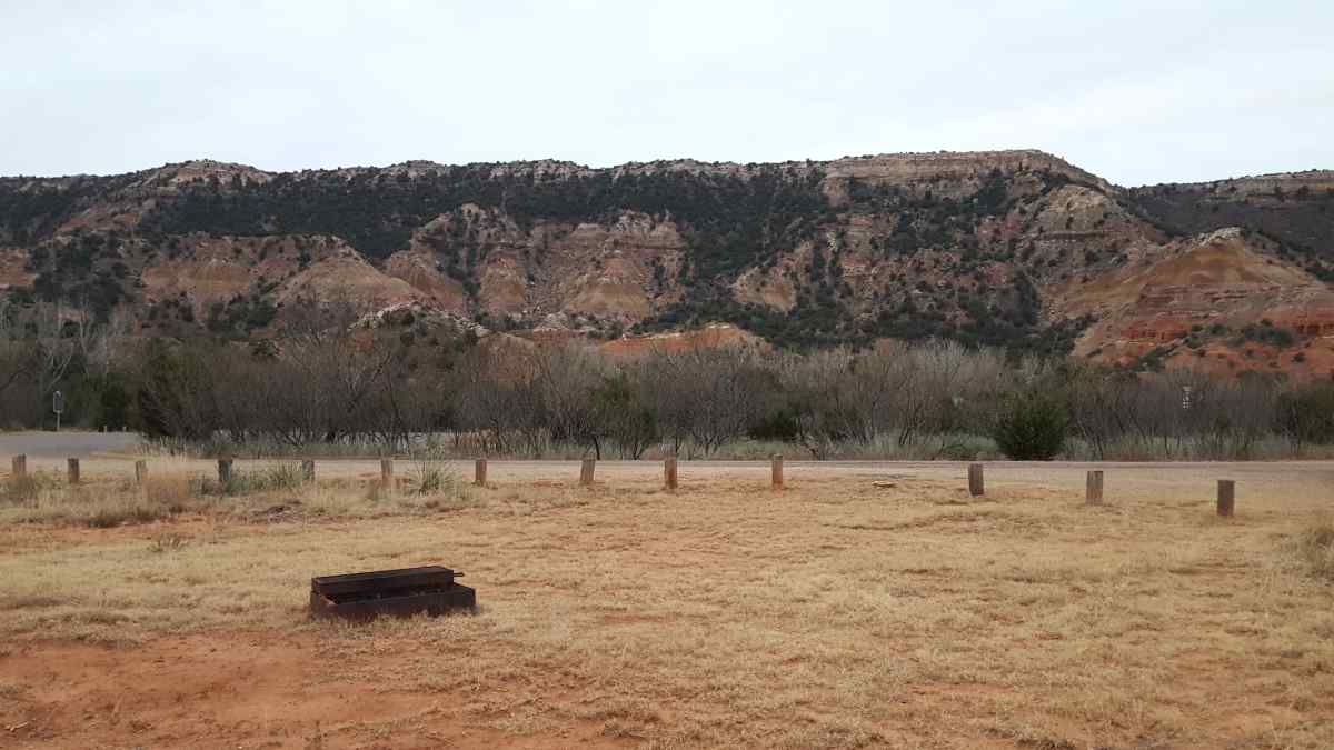 An fire ring with a grill in an open area at the Equestrian Camp Area.  