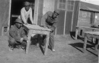 CCC men posing by a table they have built.