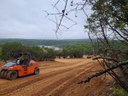 Road crew smoothing dirt for road to boat ramp. The lake is in the distance.