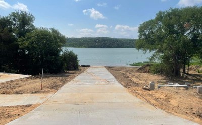 Paved boat ramp leading down to a lake.