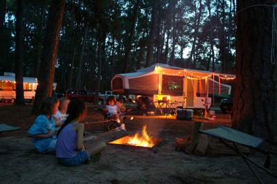 Family sitting around a campfire at sunset