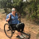 Woman using an all terrain wheelchair on a trail