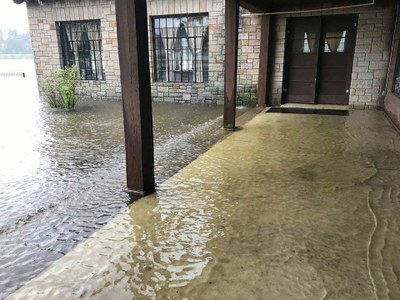 Water covering the porch of park building