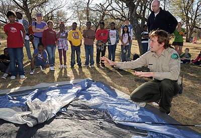 Park ranger shows families how to set up tent