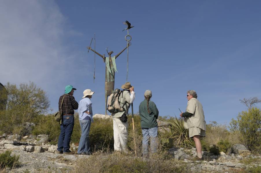 Hikers Around Shaman Sculpture