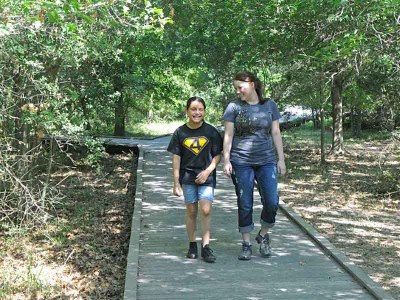 A woman and young girl walk along one of the boardwalk trails at the park