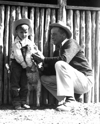 Rancher and small boy holding an animal