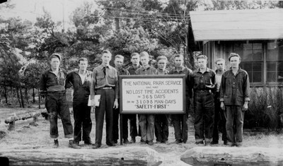 Group of CCC workers by NPS safety sign proclaiming "Safety First."