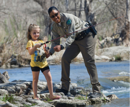 Game Warden assisting child by creek fishing.PNG